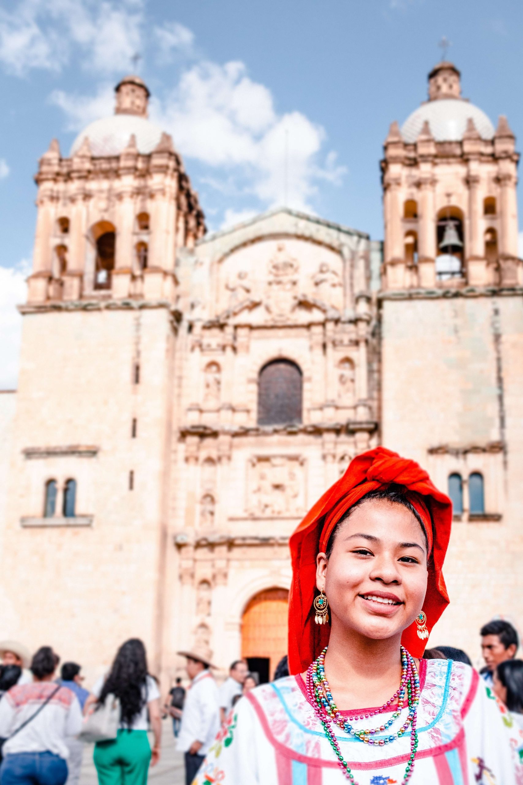 mexican woman having a red cap on head and she is smiling 
