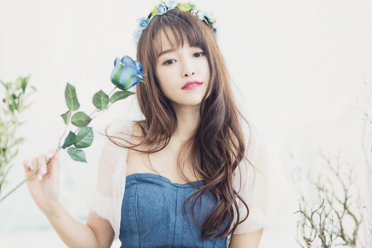 Korean girl holding blue rose in right hand