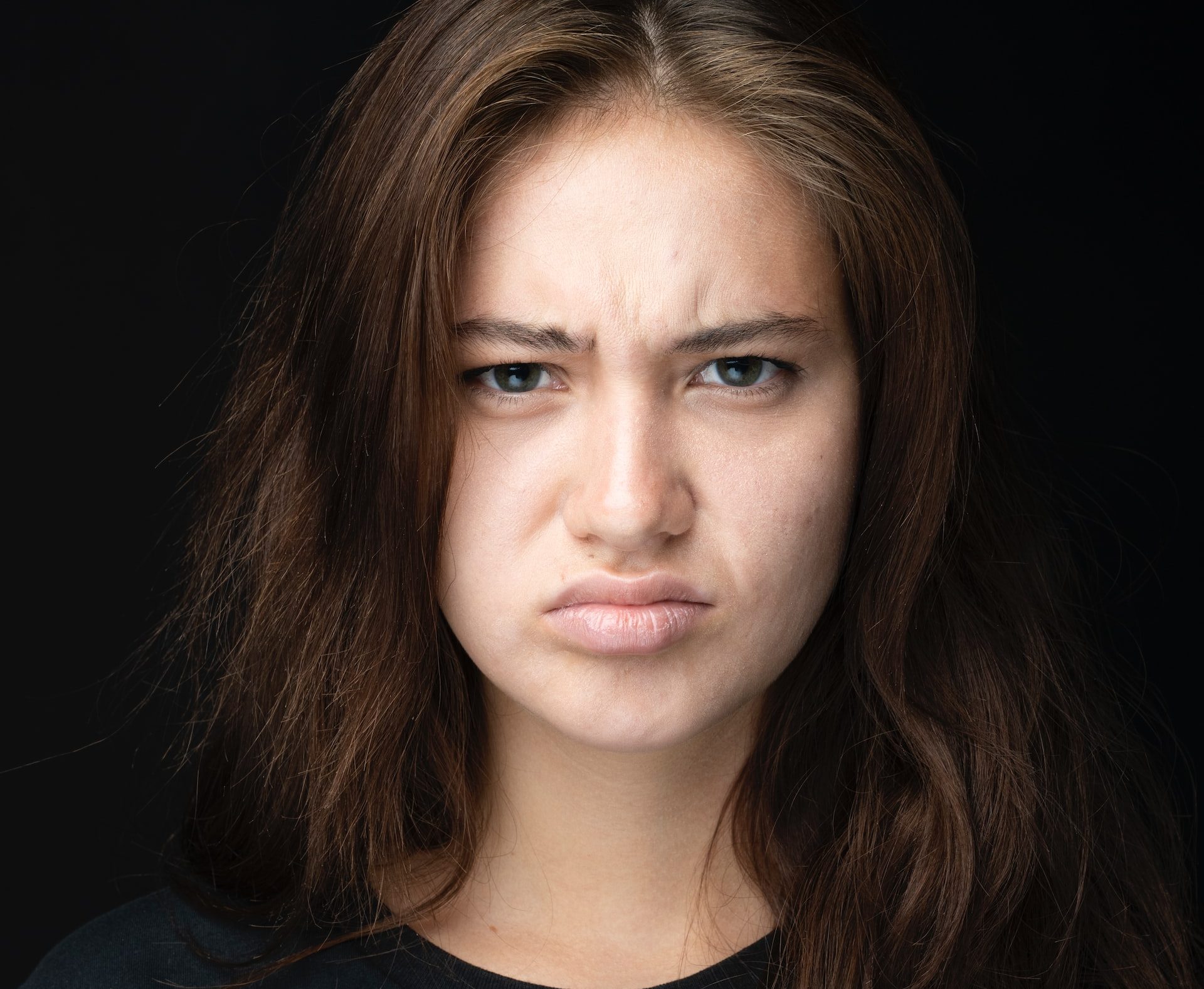 Girl wearing black top irritated due aging of her skin