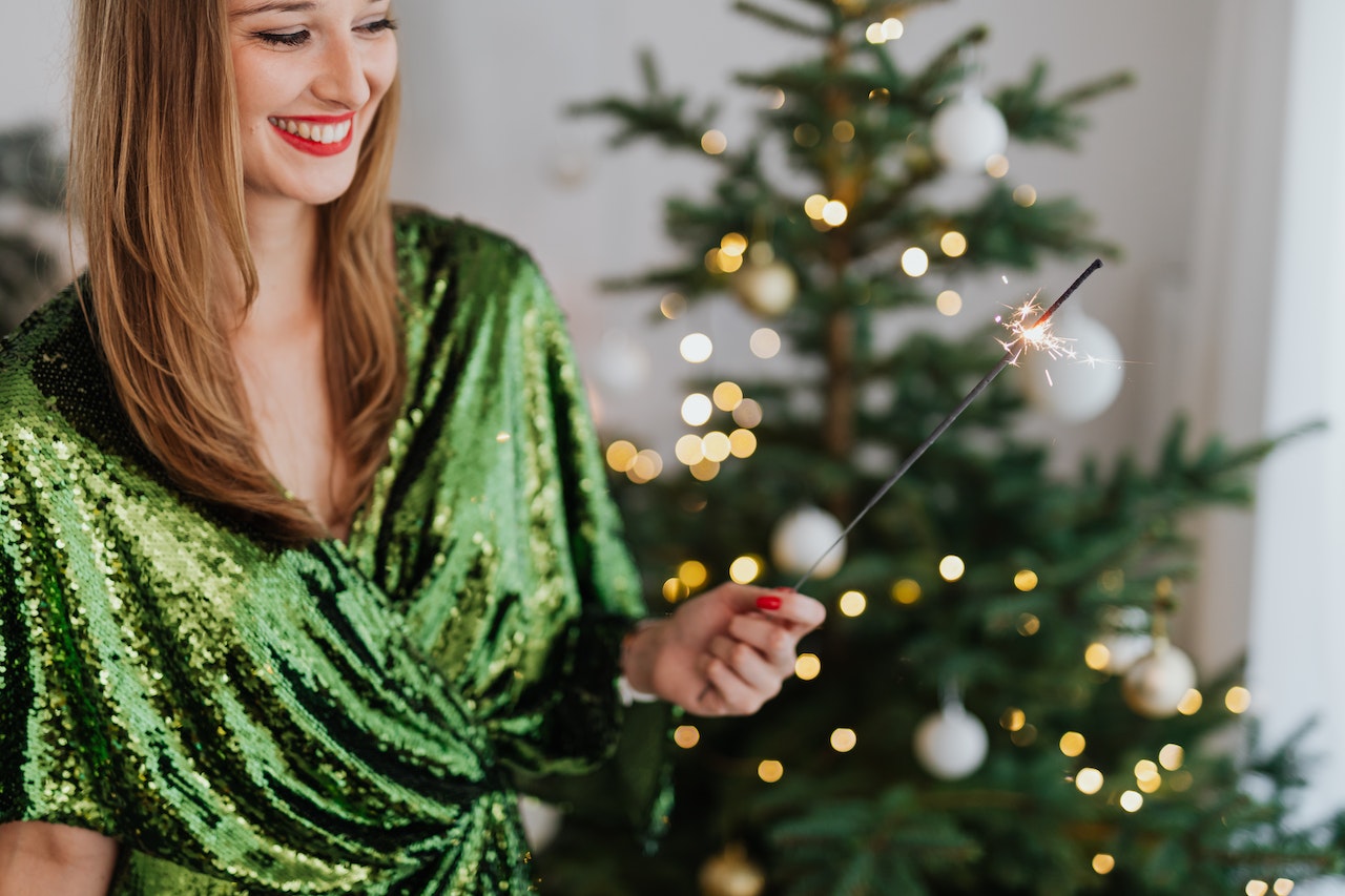 Woman is smiling and wore a green dress during christmas celebration