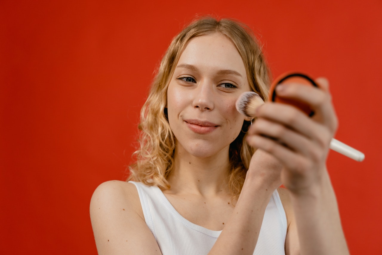 Girl wearing white top applying