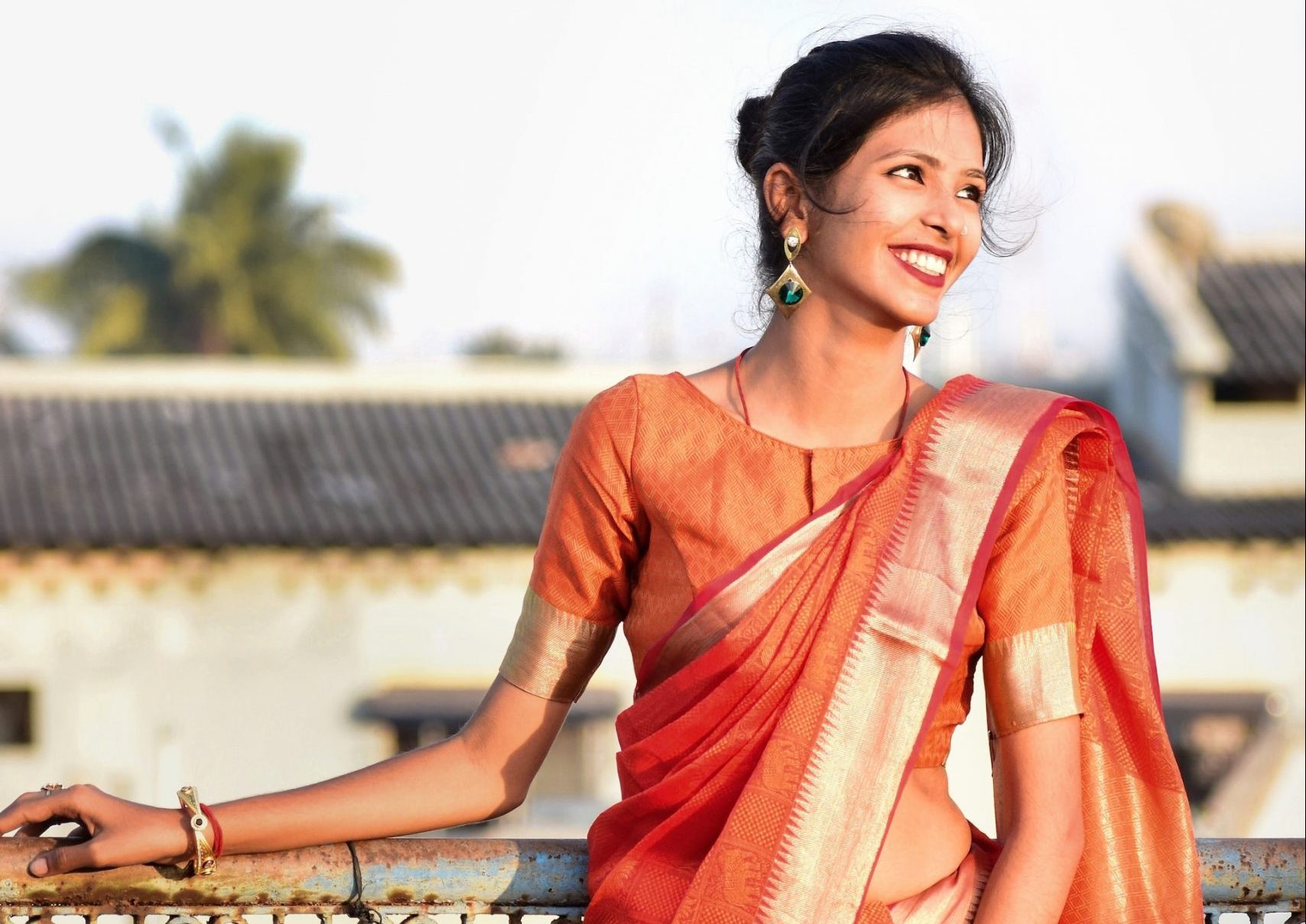 indian woman wore a red saree and smiling