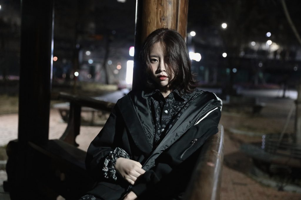 Korean beauty sitting and wearing black jacket