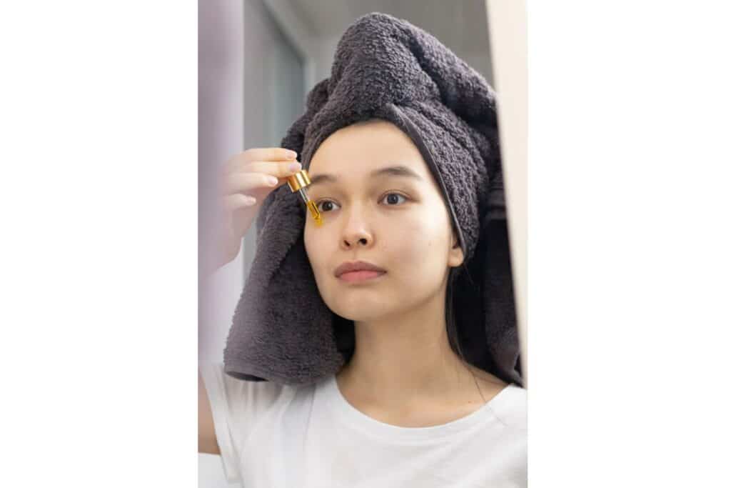 woman using niacinamide serum on her oily face